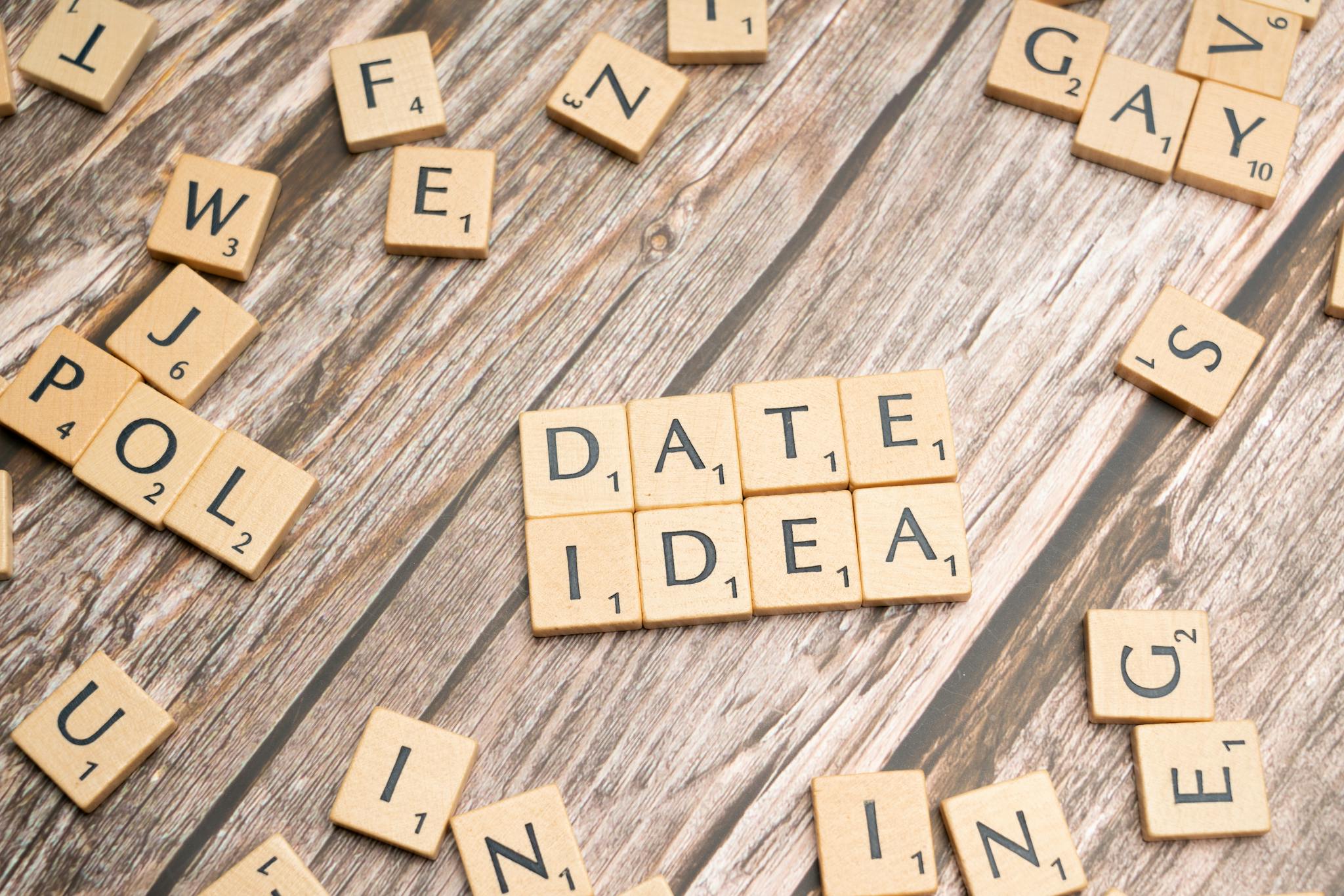 Letter tiles spelling 'Date Idea' on a wooden surface, suggesting creative meeting plans.
